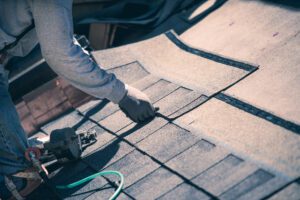 Roofer installing asphalt shingles