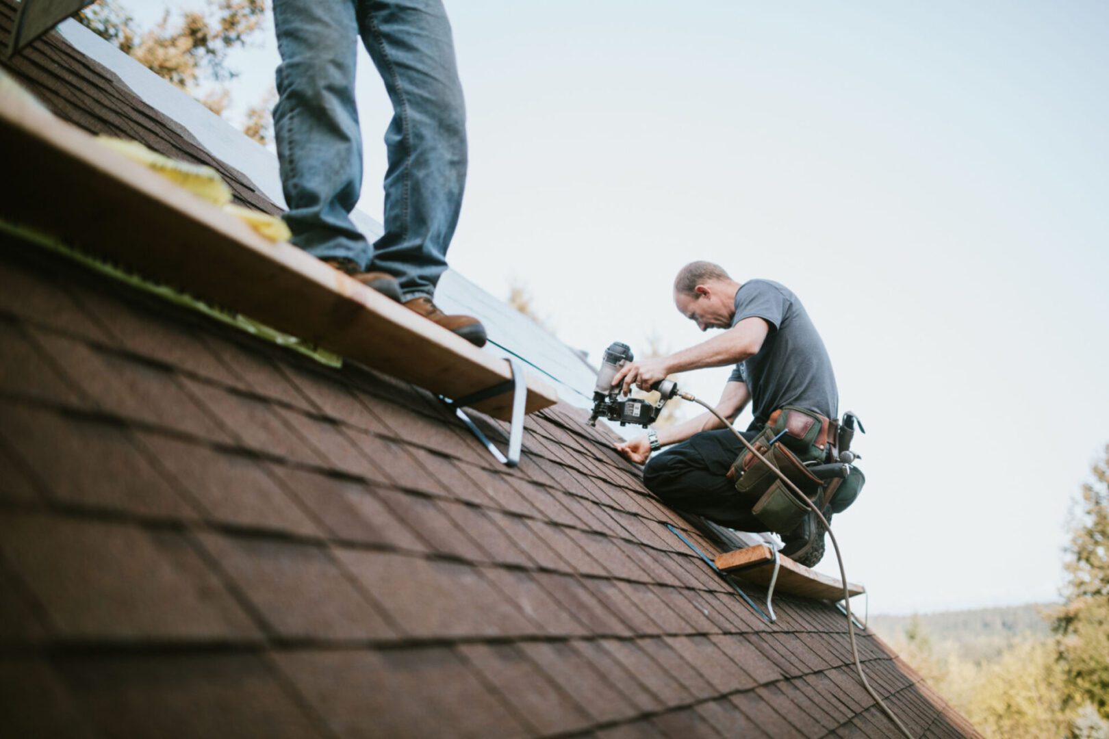 Men installing roof shingles
