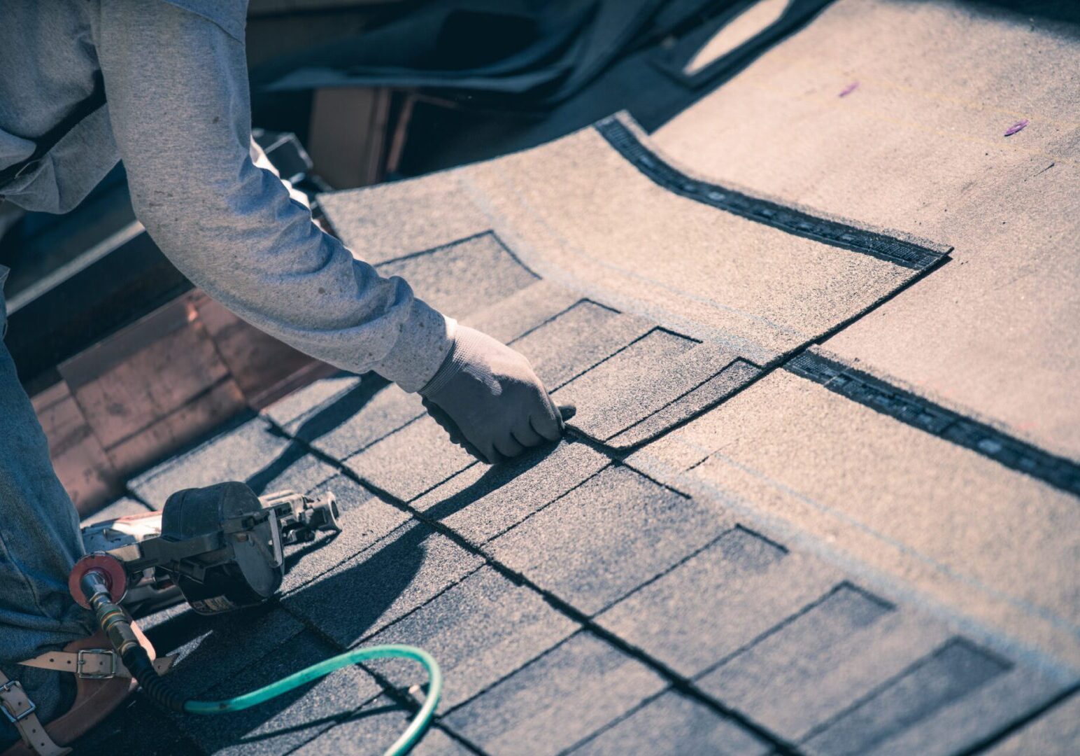 Roofer installing asphalt shingles